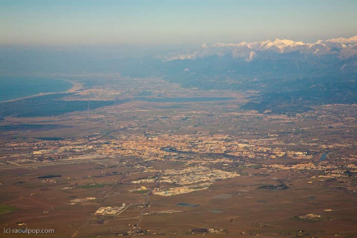 On a Ryanair flight above the city of Pisa, in Tuscany, Italy. The Mediterranean Sea is visible in the upper left.
